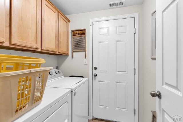 laundry room featuring visible vents, cabinet space, and separate washer and dryer