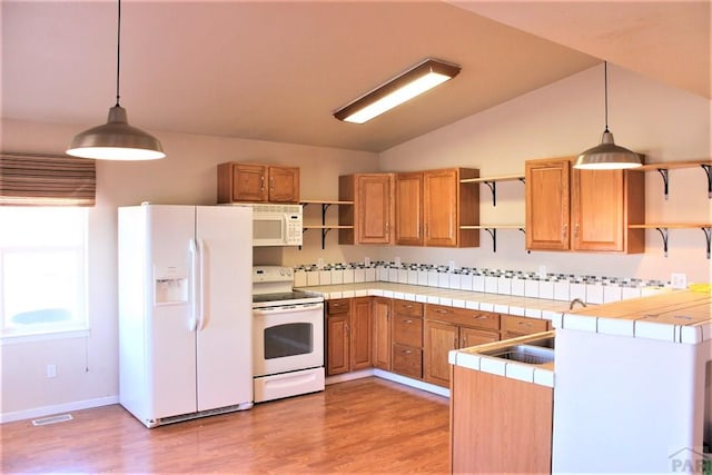 628 S Blakeland Ct, Pueblo West, CO 81007 - kitchen with open shelves, white appliances, tile countertops, lofted ceiling, and light wood-style floors