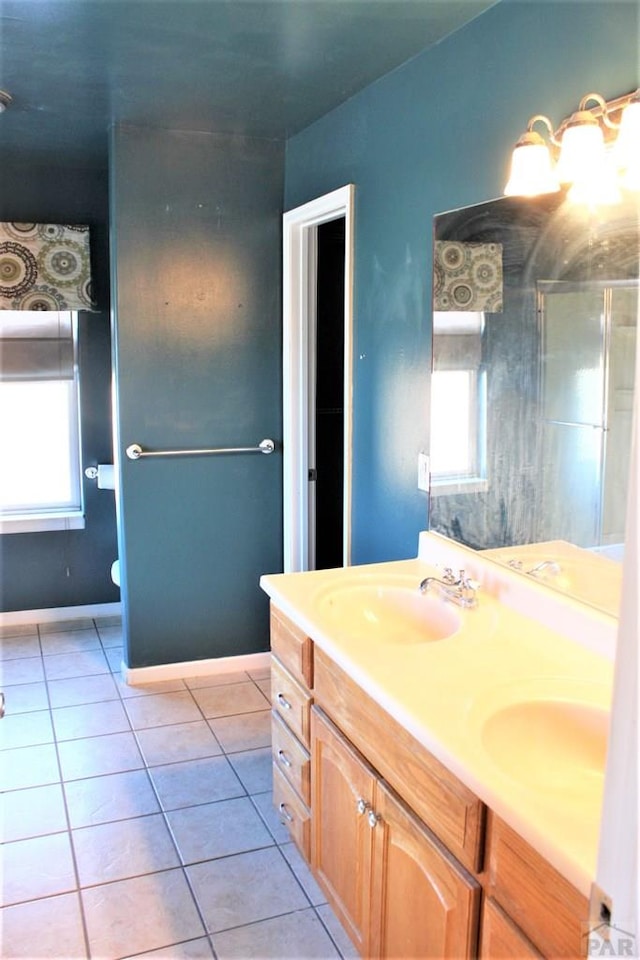 628 S Blakeland Ct, Pueblo West, CO 81007 - full bathroom with double vanity, tile patterned floors, and plenty of natural light