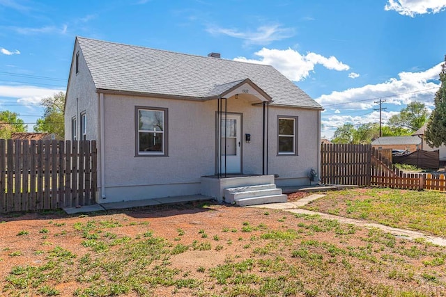 1902 E 12th St, Pueblo, CO 81001 - bungalow-style house featuring a fenced backyard, roof with shingles, and stucco siding