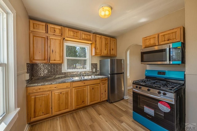 1902 E 12th St, Pueblo, CO 81001 - kitchen with stainless steel appliances, a sink, arched walkways, and light wood finished floors
