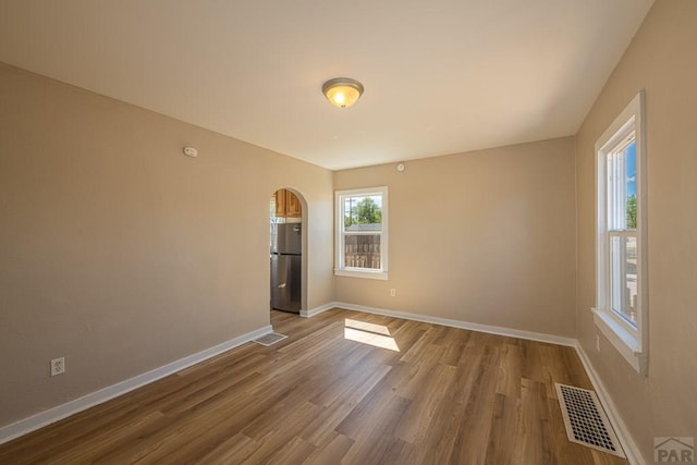 1902 E 12th St, Pueblo, CO 81001 - empty room with wood finished floors, baseboards, and arched walkways