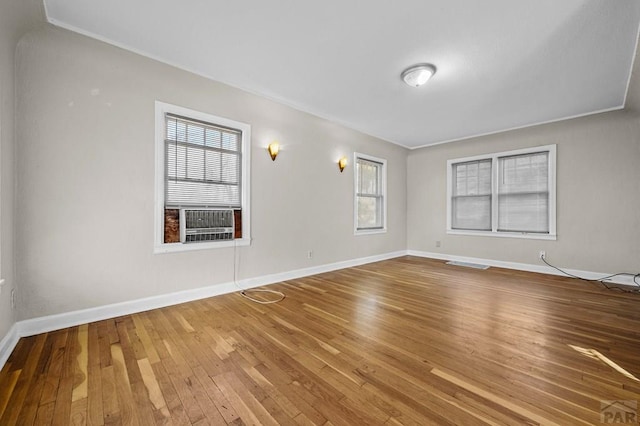 empty room featuring visible vents, baseboards, and wood finished floors