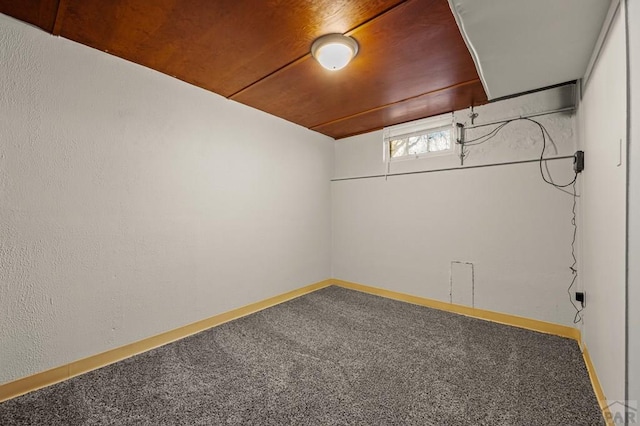 unfurnished room featuring carpet floors, wood ceiling, and baseboards