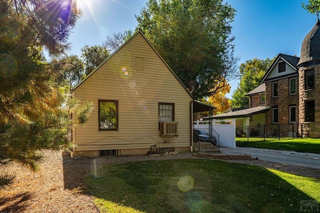 rear view of property featuring fence and a lawn