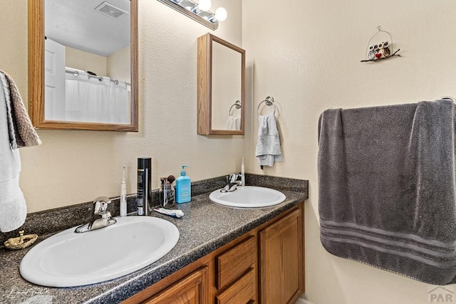 full bathroom featuring double vanity, a sink, and visible vents