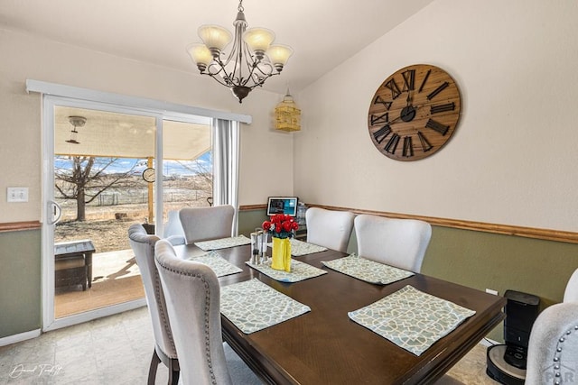 dining area featuring a chandelier and baseboards