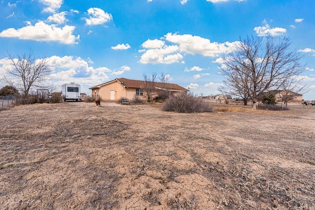 view of side of property featuring fence and stucco siding