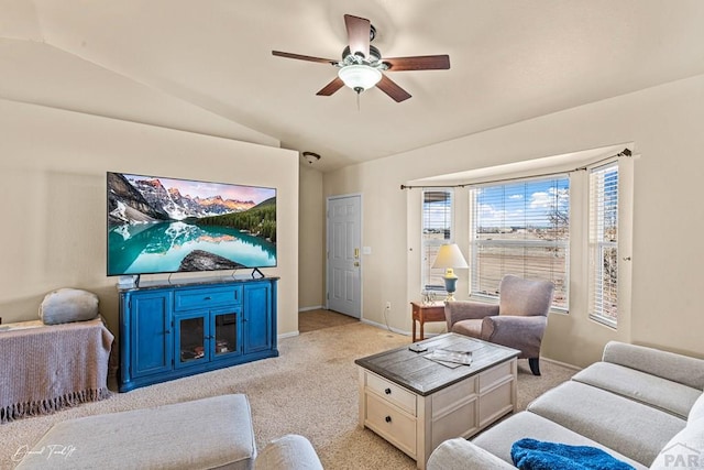 living area with lofted ceiling, ceiling fan, light carpet, and baseboards