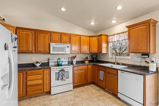 kitchen with white appliances, dark countertops, a sink, and brown cabinets