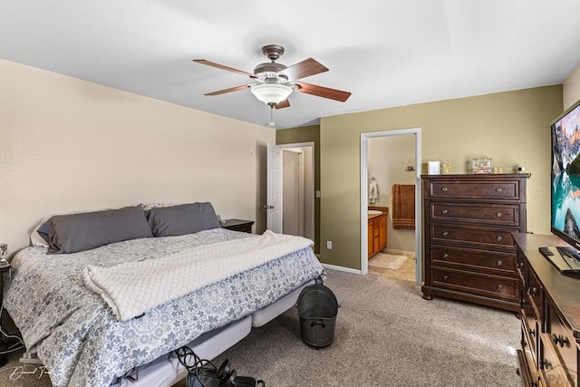 bedroom featuring a ceiling fan, light carpet, baseboards, and ensuite bathroom