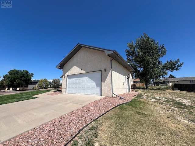 view of home's exterior featuring concrete driveway, fence, an attached garage, and stucco siding