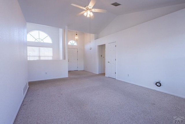 empty room with visible vents, carpet flooring, vaulted ceiling, ceiling fan, and baseboards