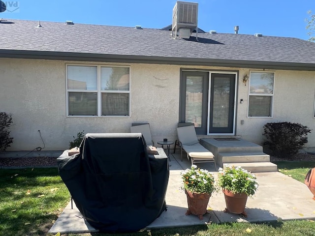 back of house featuring central AC, roof with shingles, a patio area, and stucco siding