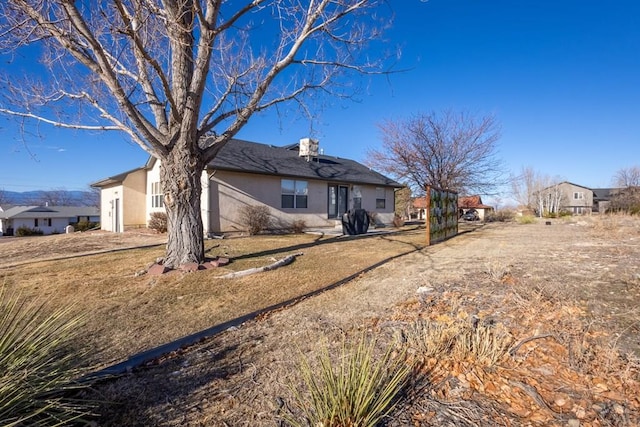 rear view of house featuring stucco siding