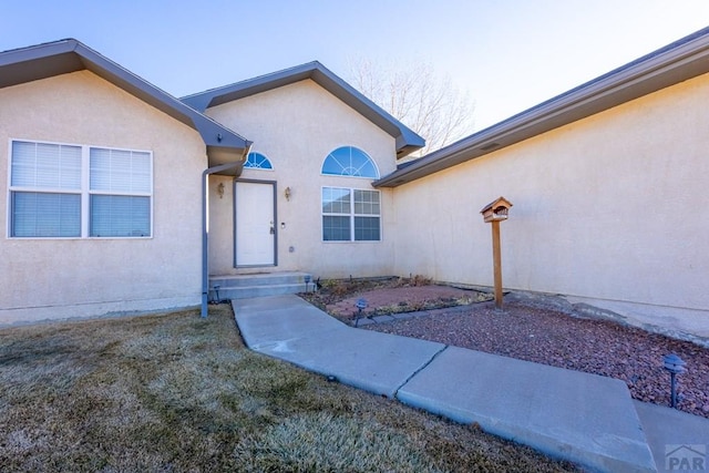 entrance to property with stucco siding