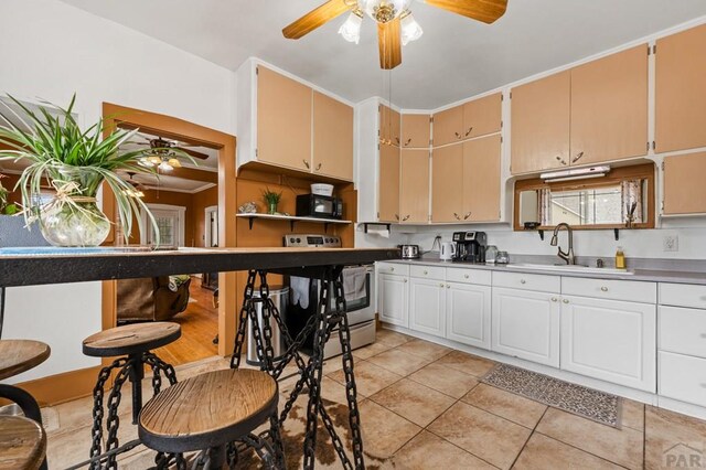 1802 E Routt Ave, Pueblo, CO 81004 - kitchen featuring black microwave, ceiling fan, a sink, and light tile patterned floors