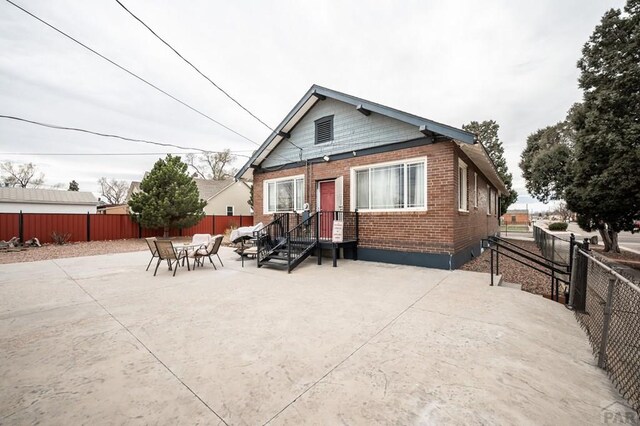 1802 E Routt Ave, Pueblo, CO 81004 - back of house featuring brick siding, a fenced backyard, and a patio area