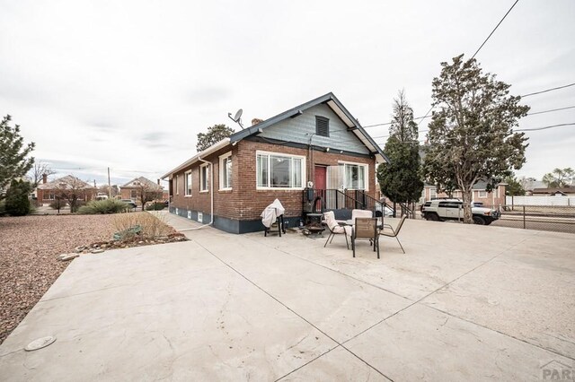 1802 E Routt Ave, Pueblo, CO 81004 - rear view of house featuring brick siding, fence, and a patio area
