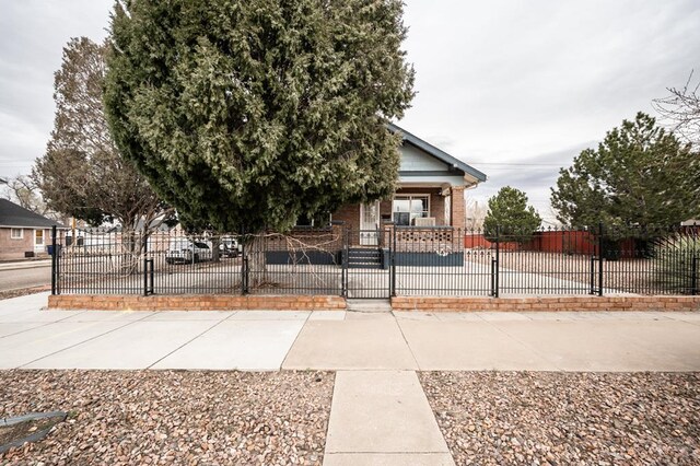 1802 E Routt Ave, Pueblo, CO 81004 - view of front of home with brick siding, a gate, and a fenced front yard