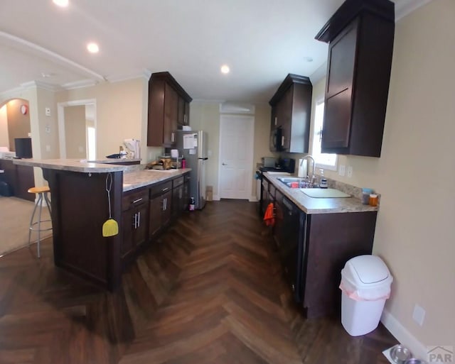 999 Fortino Blvd Unit 108, Pueblo, CO 81008 - kitchen featuring black microwave, crown molding, a breakfast bar area, dark brown cabinets, and freestanding refrigerator