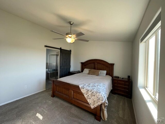 bedroom featuring a ceiling fan, dark carpet, baseboards, and a barn door