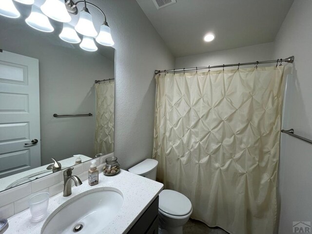 bathroom with toilet, curtained shower, and vanity