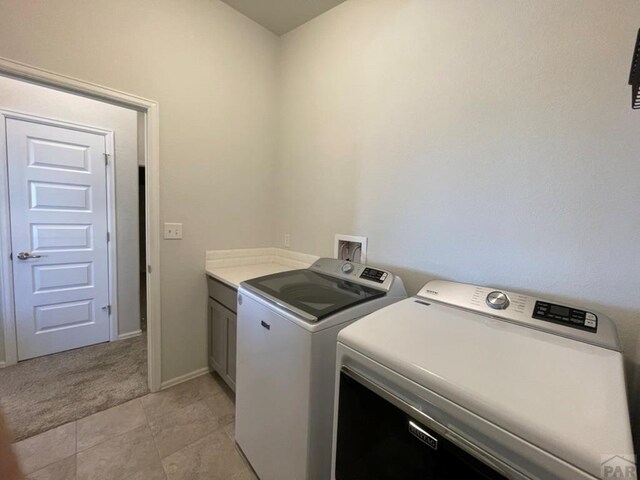 laundry area featuring light carpet, cabinet space, baseboards, and independent washer and dryer