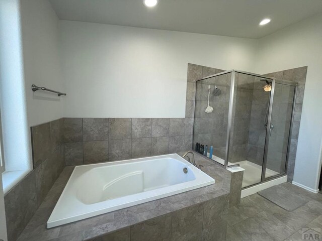 bathroom featuring a stall shower, a bath, and recessed lighting