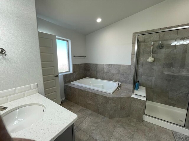 bathroom featuring a garden tub, a tile shower, and vanity