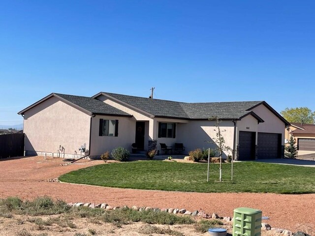 single story home with an attached garage, driveway, a front lawn, and stucco siding