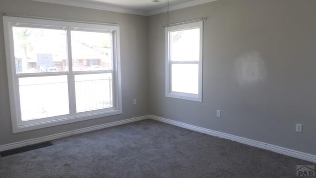 empty room featuring carpet flooring, baseboards, visible vents, and ornamental molding
