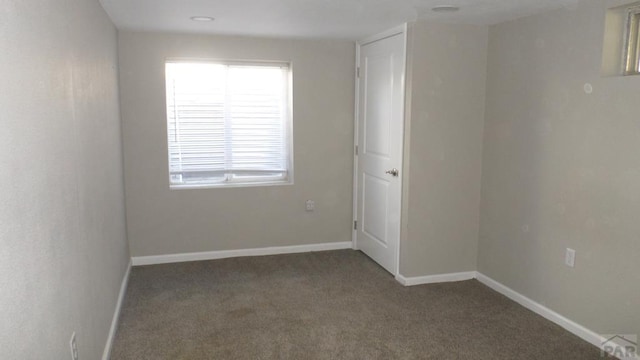 spare room with baseboards and carpet flooring
