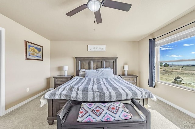 bedroom featuring baseboards, ceiling fan, and light colored carpet