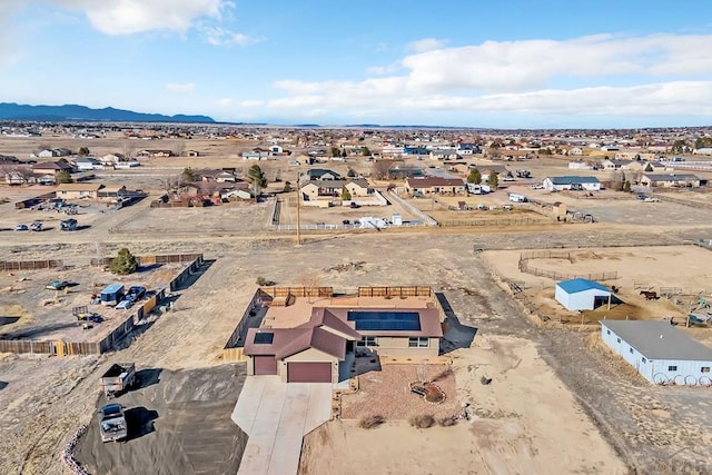 drone / aerial view featuring view of desert, a mountain view, and a residential view