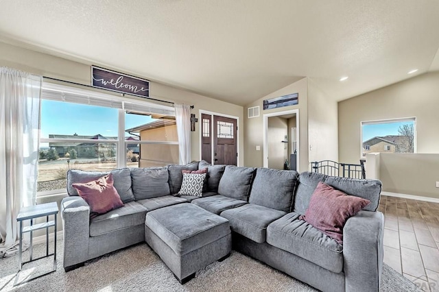 living room with lofted ceiling, plenty of natural light, and visible vents