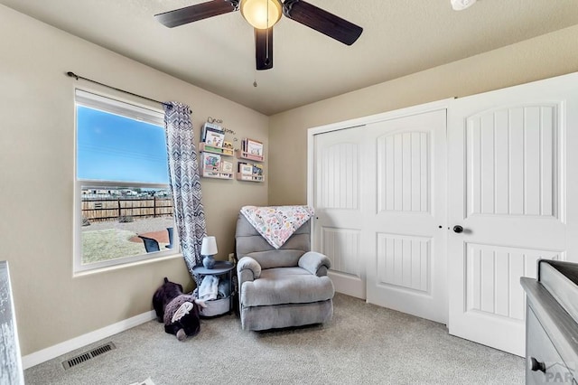 living area featuring carpet floors, visible vents, and baseboards