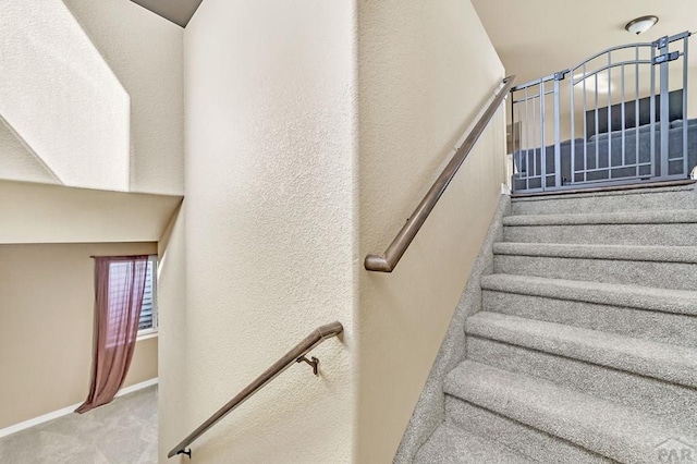 staircase featuring carpet and baseboards