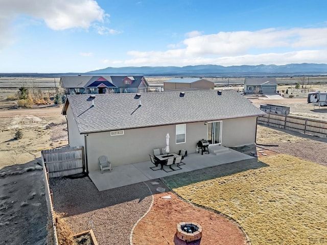 back of house with a shingled roof, a fenced backyard, a patio area, a mountain view, and stucco siding