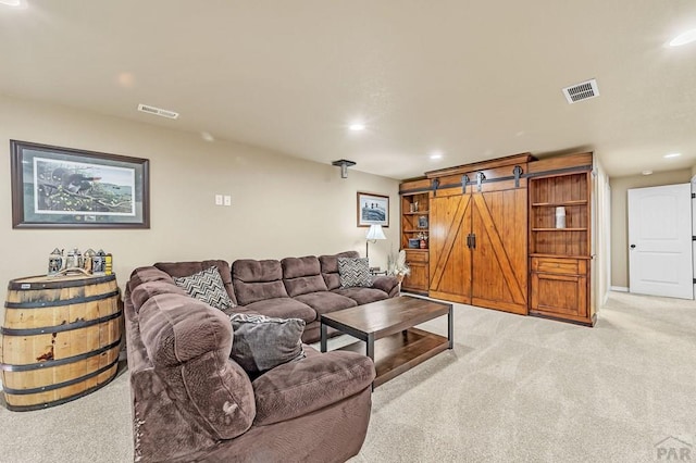 living room with light colored carpet, visible vents, recessed lighting, and a barn door