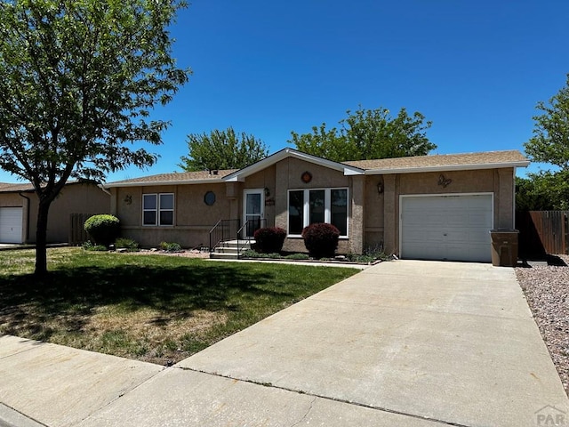 ranch-style house with concrete driveway, a front yard, an attached garage, and stucco siding