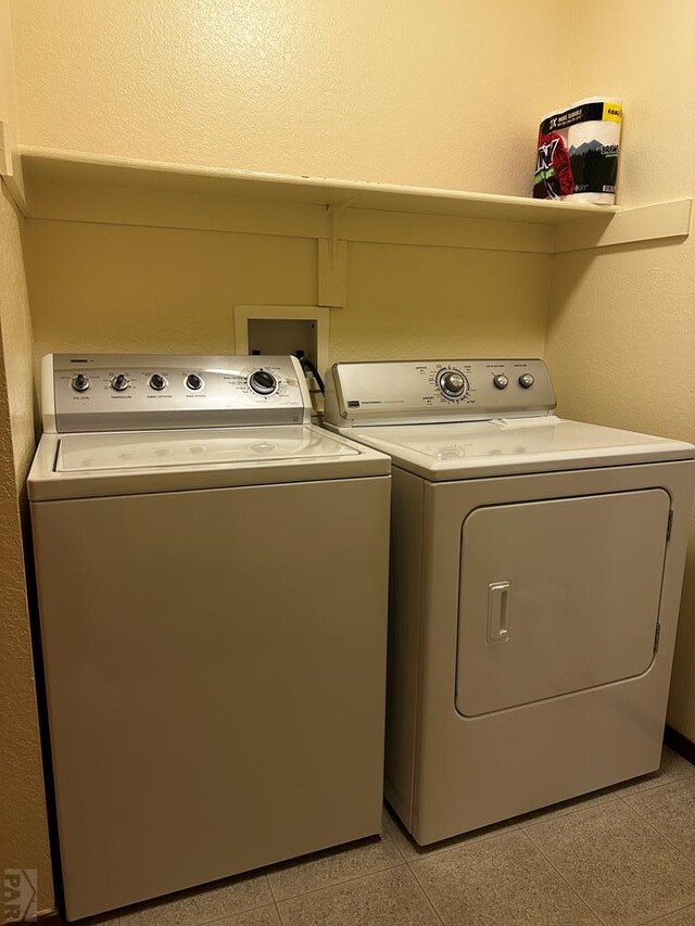 laundry area featuring light tile patterned floors, laundry area, and washer and clothes dryer