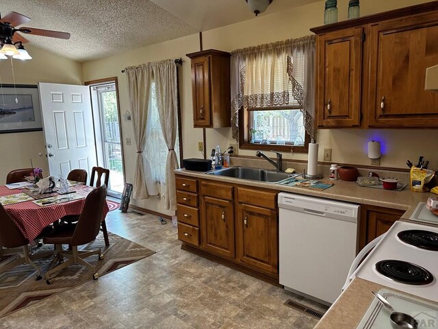 kitchen featuring light countertops, white appliances, a sink, and visible vents