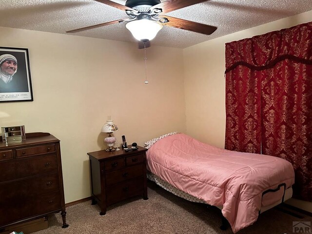 bedroom featuring a ceiling fan, light colored carpet, a textured ceiling, and baseboards