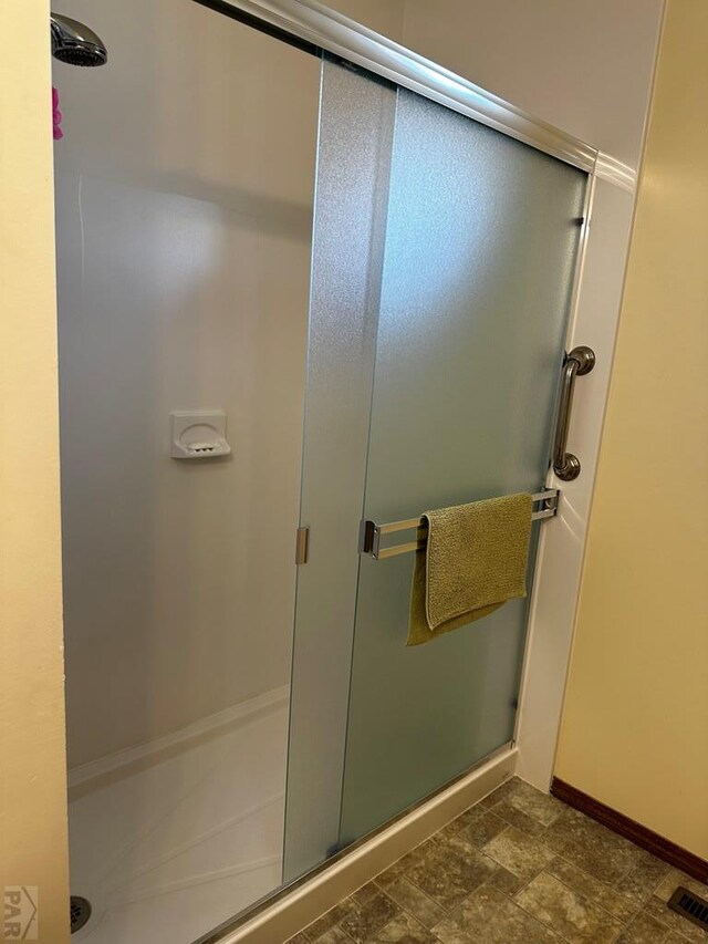 full bathroom featuring a stall shower, visible vents, and baseboards