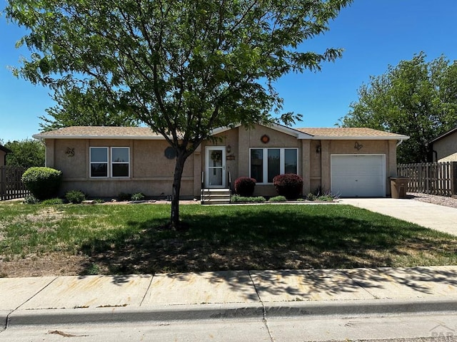 ranch-style home with driveway, fence, an attached garage, and stucco siding