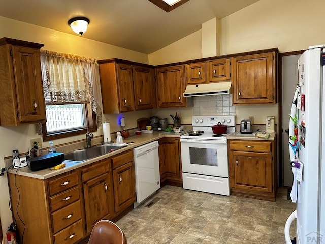 kitchen featuring light countertops, vaulted ceiling, a sink, white appliances, and under cabinet range hood