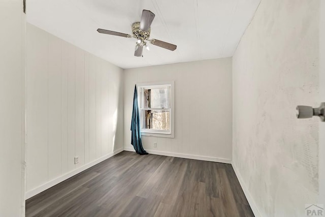 unfurnished room with dark wood-style floors, baseboards, and a ceiling fan