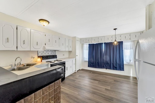 kitchen featuring white appliances, hanging light fixtures, light countertops, white cabinetry, and a sink