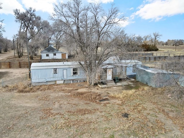 view of front of house featuring a rural view and fence